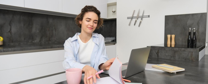 A woman sitting with a laptop preparing to plan for a kitchen remodel