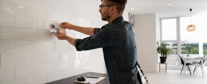 Designer comparing tile and paint color samples during a Maryland kitchen remodel planning session