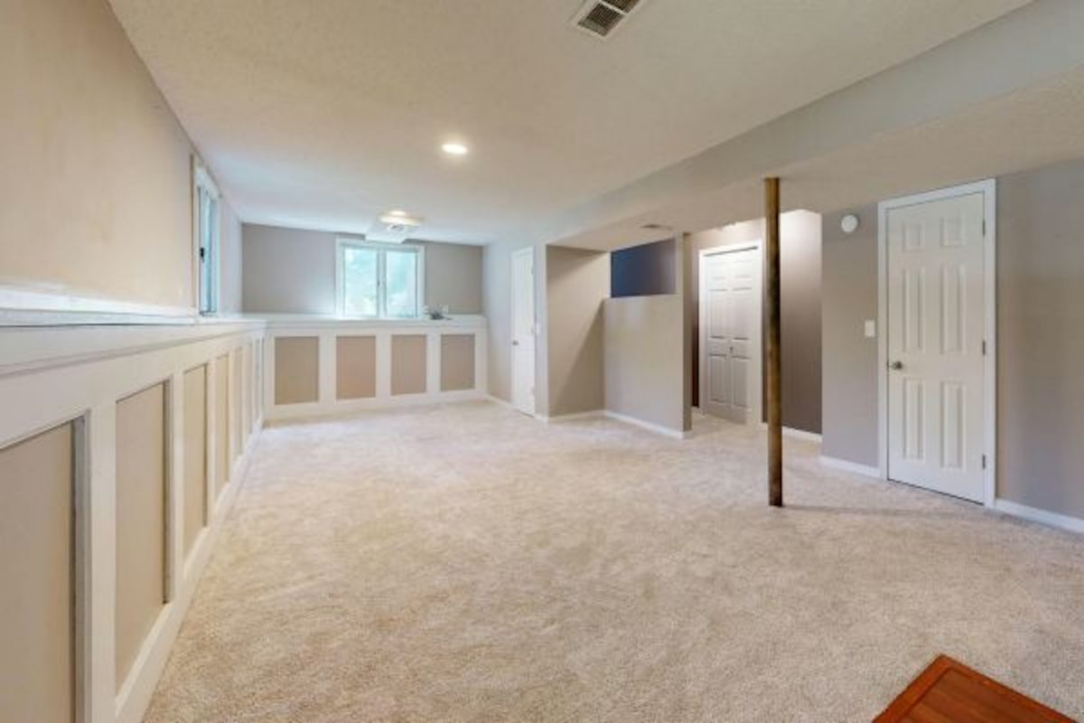 Finished Basement Example in Maryland Home With Fully Remodeled Lower Level Fully finished basement in a Maryland home with carpet flooring, finished walls, ceiling, and lighting showing code-compliant livable lower-level space suitable for occupancy