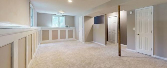 Fully finished basement in a Maryland home with carpet flooring, finished walls, ceiling, and lighting showing code-compliant livable lower-level space suitable for occupancy