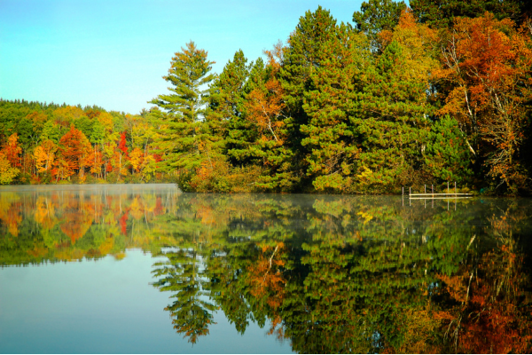 A scenic view of a lake in Columbia, Maryland surrounded by autumn trees, representing a prime location for custom modular home building.
