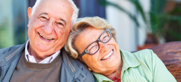 Smiling older couple relaxing together at home, representing aging in place in Maryland