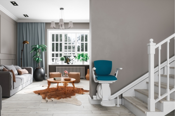 Stair Lift on a Home Staircase Blue stair lift chair parked at the bottom of a white staircase in a living room