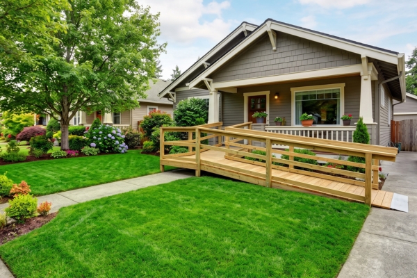 Wheelchair Ramp at a Home Entry Wooden wheelchair ramp with handrails leading from the sidewalk to the front porch of a craftsman-style home